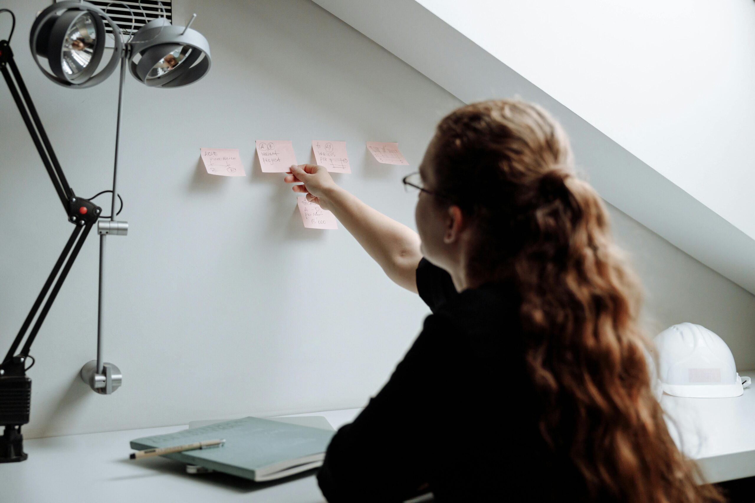 Woman at desk using post-it notes.