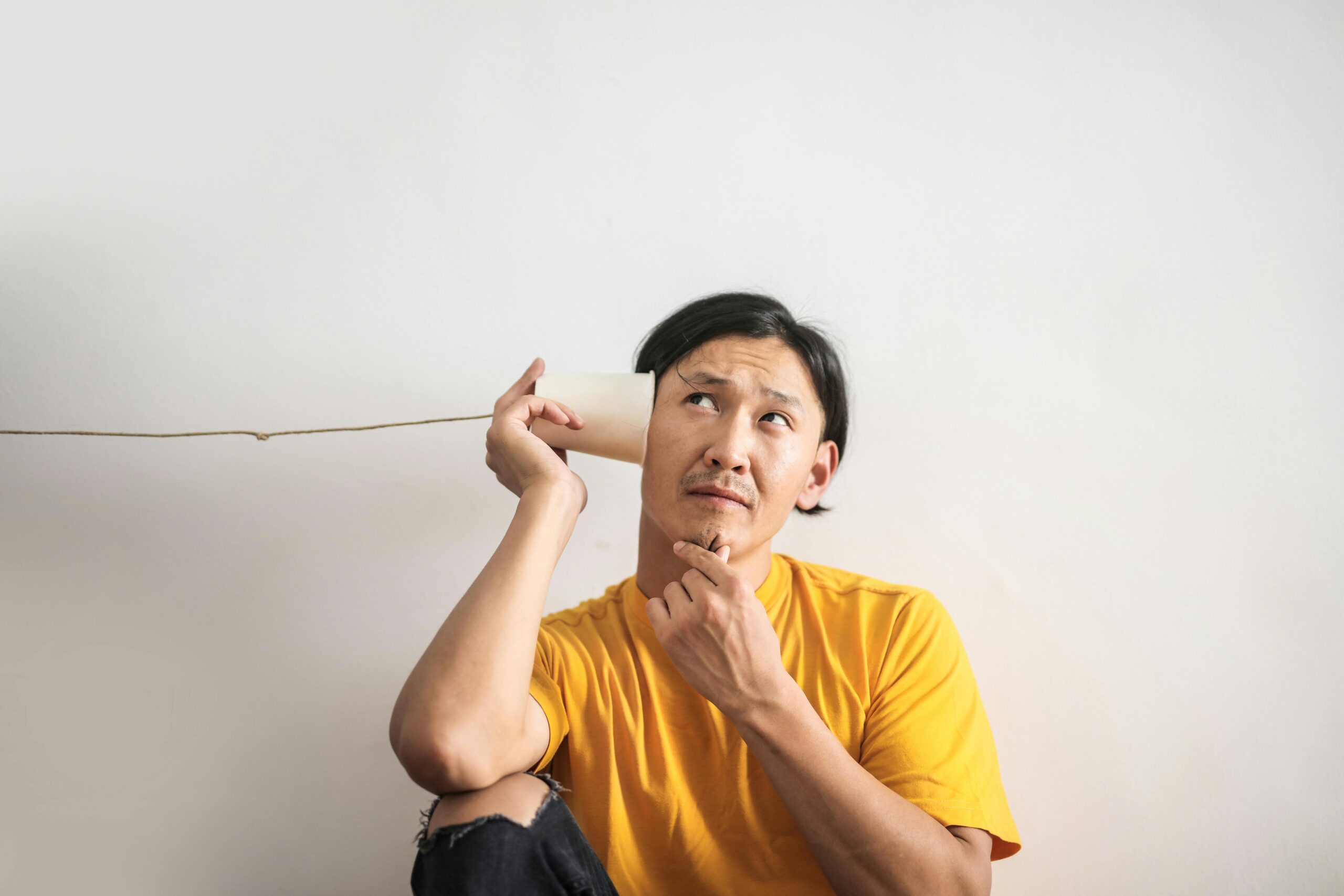 Person listening to a cup.